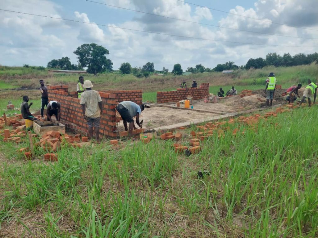 Bauarbeiter mauern Steine auf einem Fundament